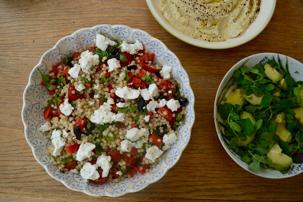 Feta, tomato and couscous salad, hummus and avocado salad