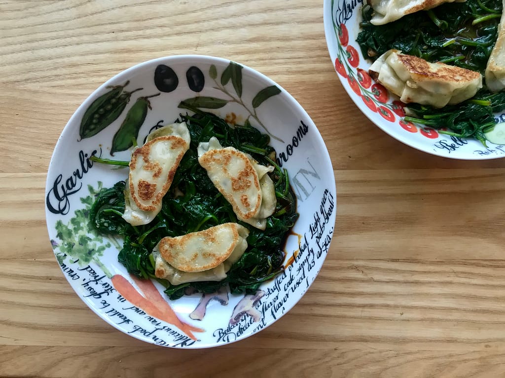 Bought gyozas on frozen spinach 